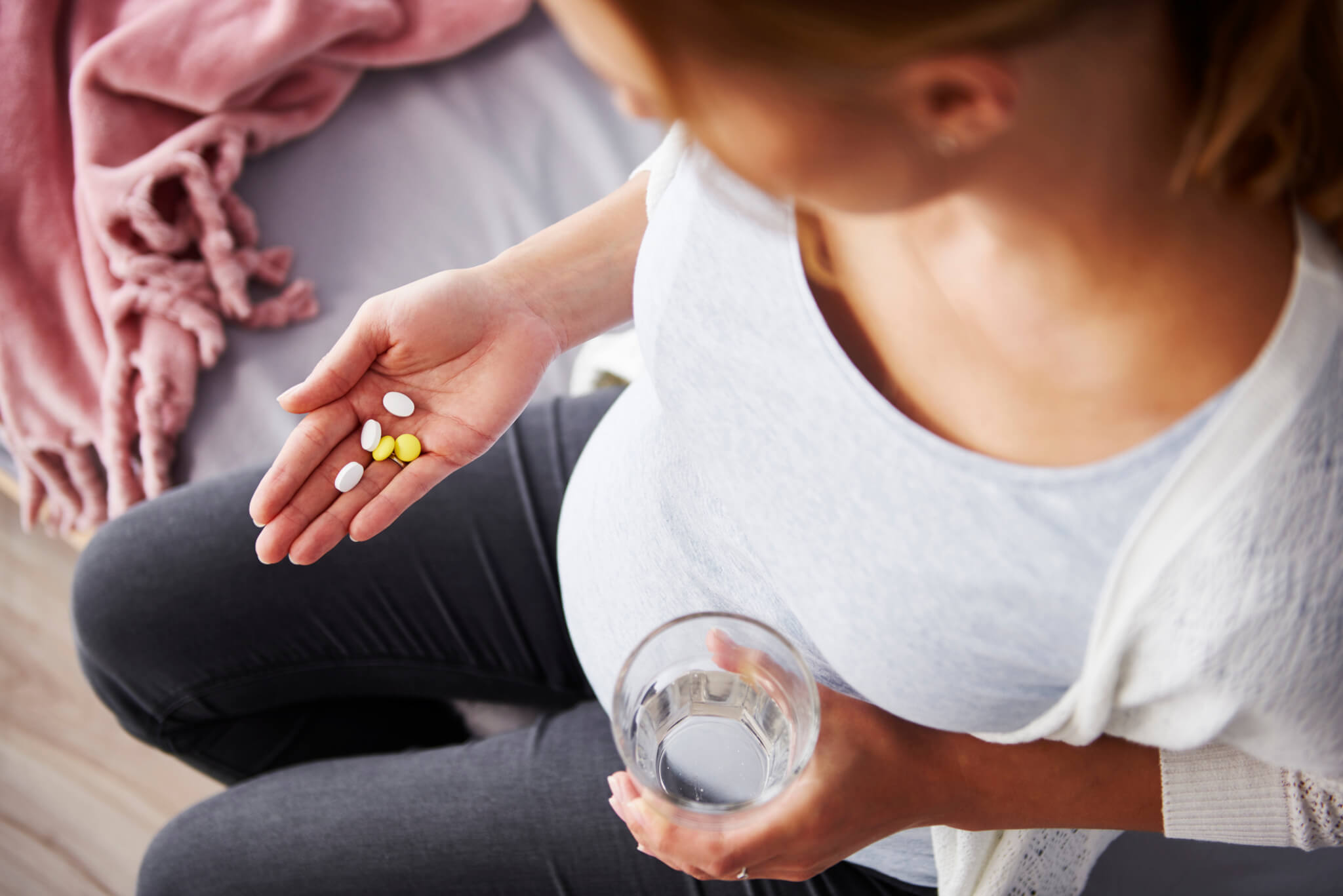 Young pregnant woman taking medicine