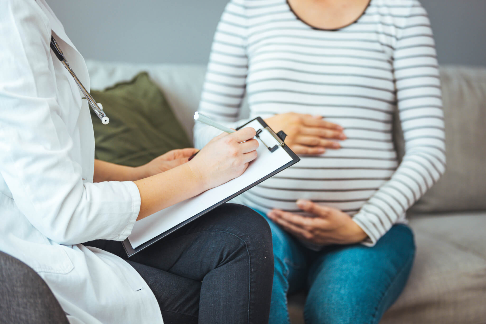 A pregnant Caucasian woman is indoors in a doctor’s office.