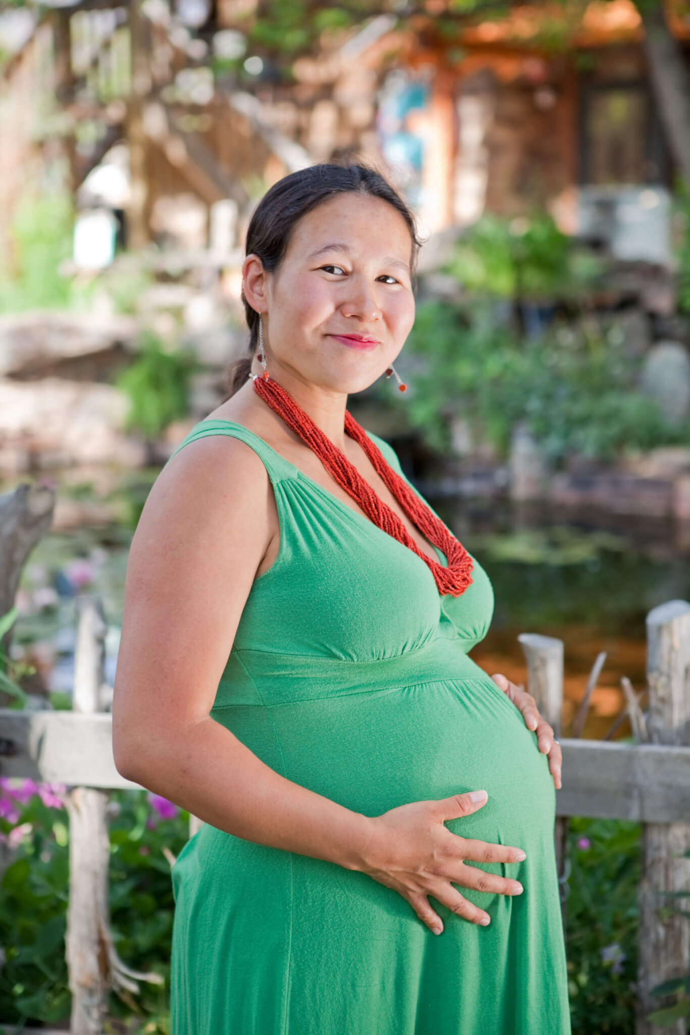 A pregnant native American woman wearing a green dress